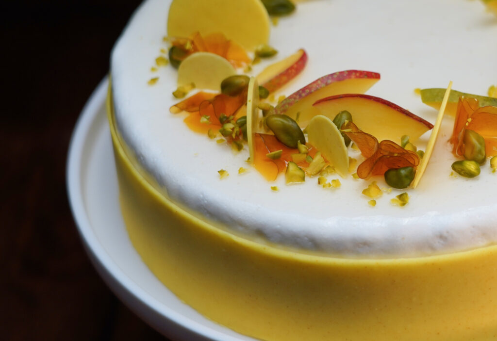 Gâteau soleil d'Hiver avec un cœur mangue-passion coco sur un financier citron vert